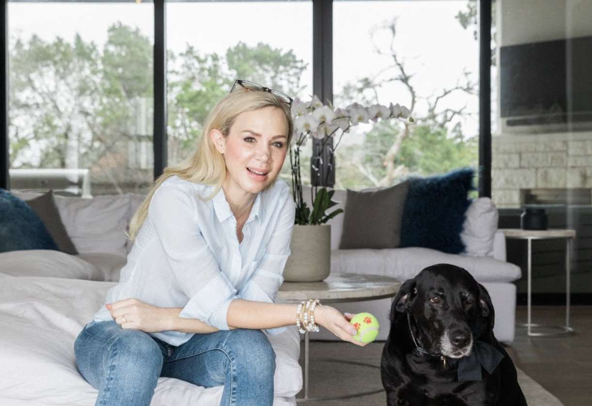 Janna Johnson in a relaxed moment with her dog, smiling and holding a tennis ball, representing joy and emotional recovery after narcissistic trauma